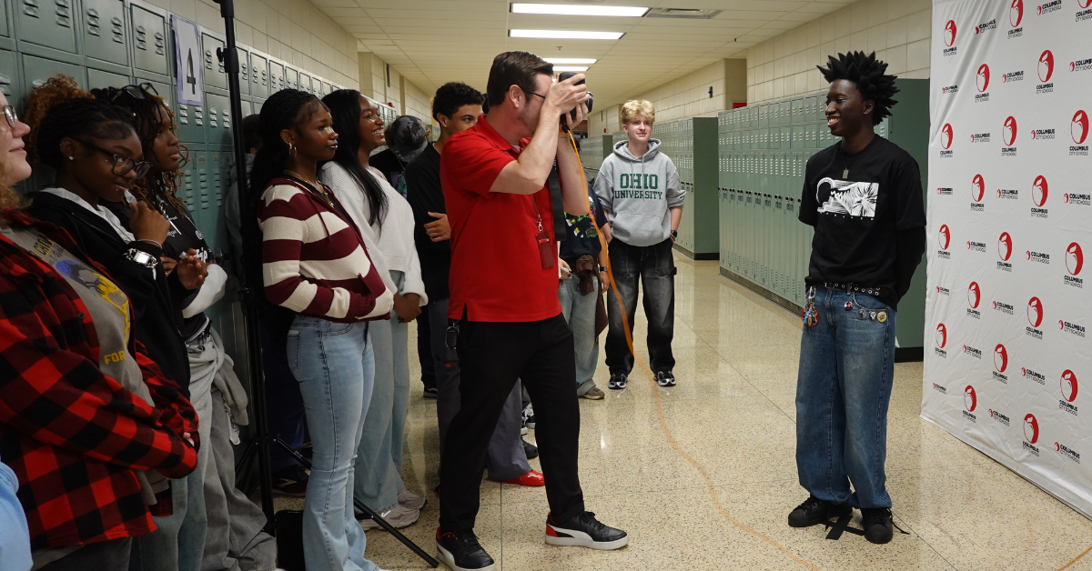 man taking photo of student surrounded by students